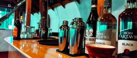 Un espace bar avec différentes bouteilles et des shakers à cocktails.