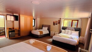 Ein Hotelzimmer mit zwei Betten, einem Schreibtisch, einem Kleiderschrank und einer Heizung.