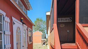 A narrow pathway leading to a building with a red exterior and a sign reading "MILTILIFE".
