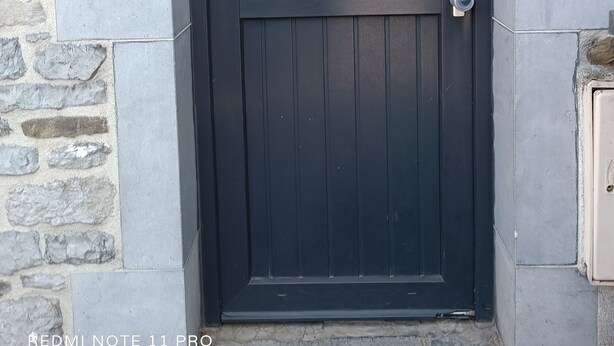 A dark-colored door with a glass panel, a metal handle, and a keypad lock. - Presqu'île de Chooz (Chooz)