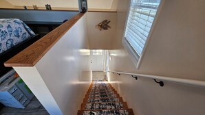 Een trap met een houten leuning en een witte muur met een decoratief houten element.