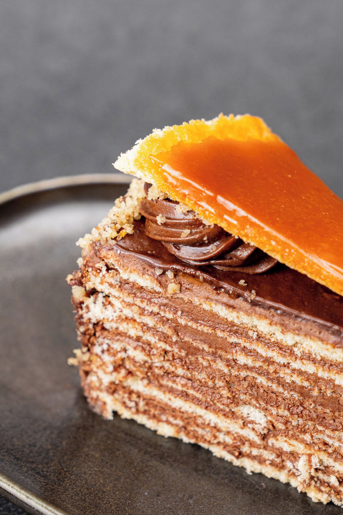 Una porción de pastel de chocolate en capas con cobertura de caramelo.