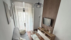 Un saló modern amb un sofà, taula de menjador i televisió.
