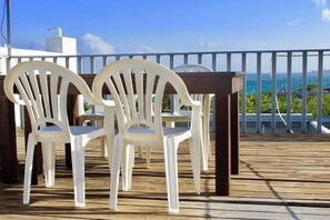A wooden deck with white plastic chairs and a white railing. - Kenting Nanwan 254 (Pingtung)