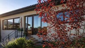 A modern house with a large window, a staircase, and a well-maintained garden. - Del Alto Reñaca Guest House (Viña del Mar)