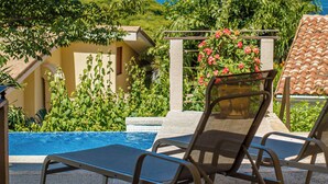 A poolside area with lounge chairs, a clear view of the ocean, and lush greenery. - Villa Cielo Casita — Pool & Ocean View, Ocotal (Playa Azul, Ocotal)
