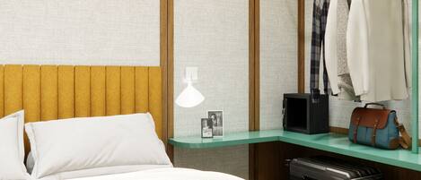 A neatly arranged hotel room with a bed, a bedside table with a lamp, a mirror, and a clothing rack with a suitcase.