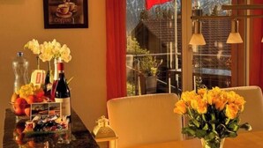 A dining area with a table set for two, a Swiss flag, and a mountain view.