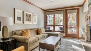 A living room with a sofa, coffee table, and artwork on the wall.