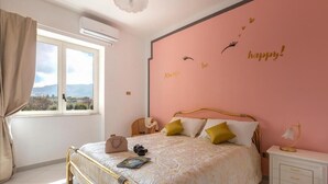 A bedroom with a bed, a nightstand, a window, and a wall with a motivational quote. - Seaview Cocò Home Piano di Sorrento SEA FRONT and FREE PARKING (Piano di Sorrento)