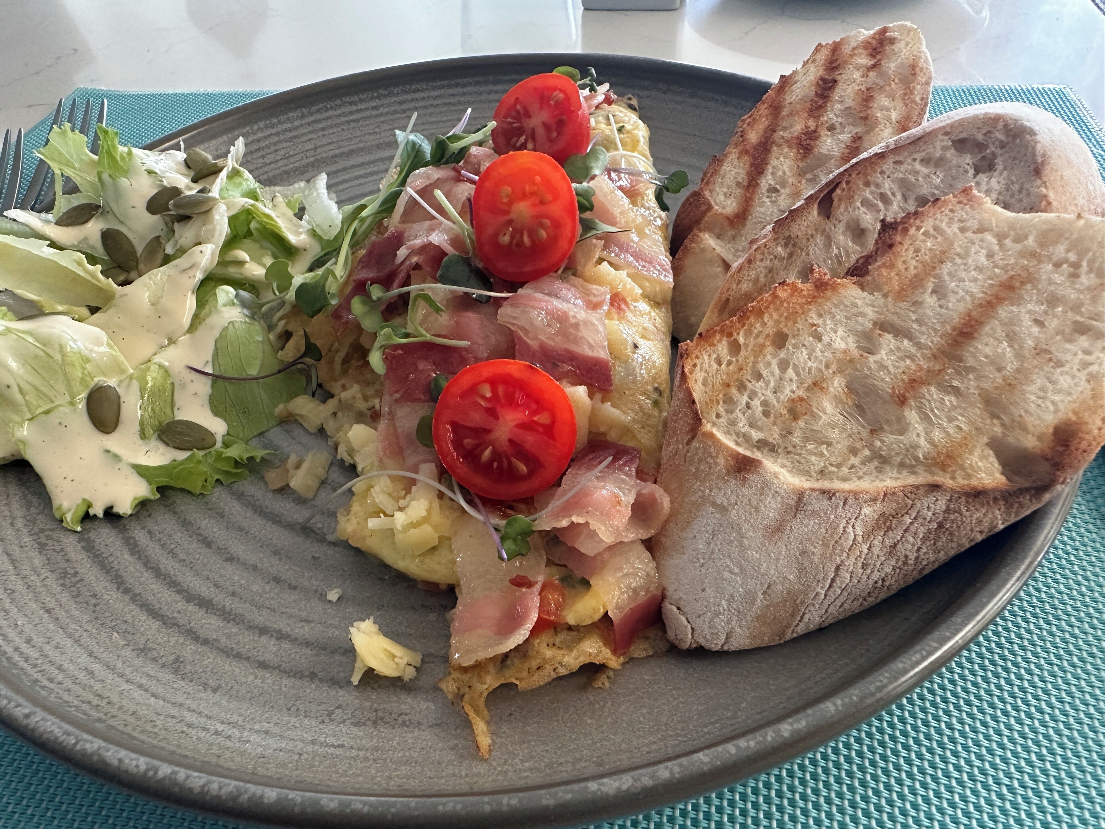 A plate with a salad, a sandwich, and toasted bread.