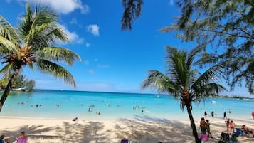In StrandnĂ€he, weiĂer Sandstrand, LiegestĂŒhle, Sonnenschirme