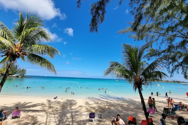In Strandnähe, weißer Sandstrand, Liegestühle, Sonnenschirme