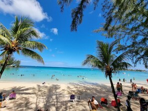 Pantai di sekitar, pasir putih, kursi berjemur, dan payung pantai
