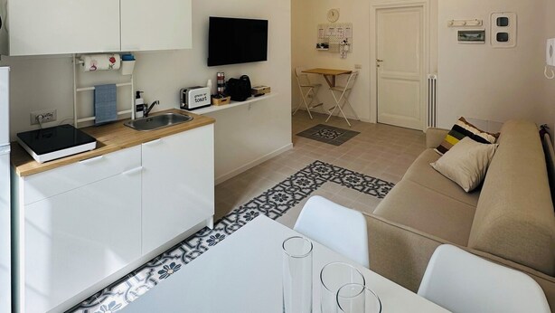 A compact living space with a kitchenette, dining area, and seating area.
