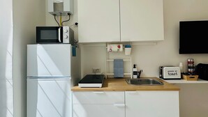 A compact kitchenette with a microwave, toaster, and small sink.