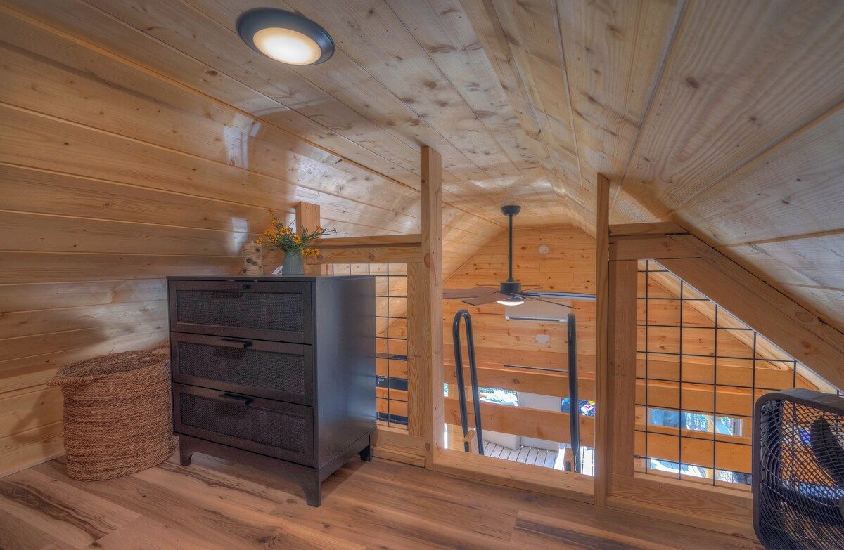 A wooden interior with a dresser, a wicker basket, and a fan.