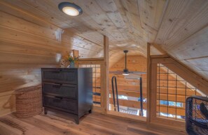 Ein Holzinterieur mit Kommode, Korbwannen und einem Ventilator.