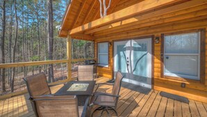 A wooden deck with outdoor seating and a glass door leading to an interior space. - Tiny Cabin - Big Amenities - King Bed & Dog Yard (Murphy)