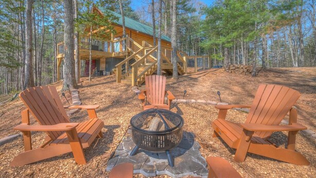 A cabin with a stone fire pit surrounded by Adirondack chairs. - Tiny Cabin - Big Amenities - King Bed & Dog Yard (Murphy)