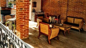 A cozy patio area with wicker furniture, a brick wall, and decorative butterflies. - Hotel Boutique Casa de las Flores     (Huajuapan)