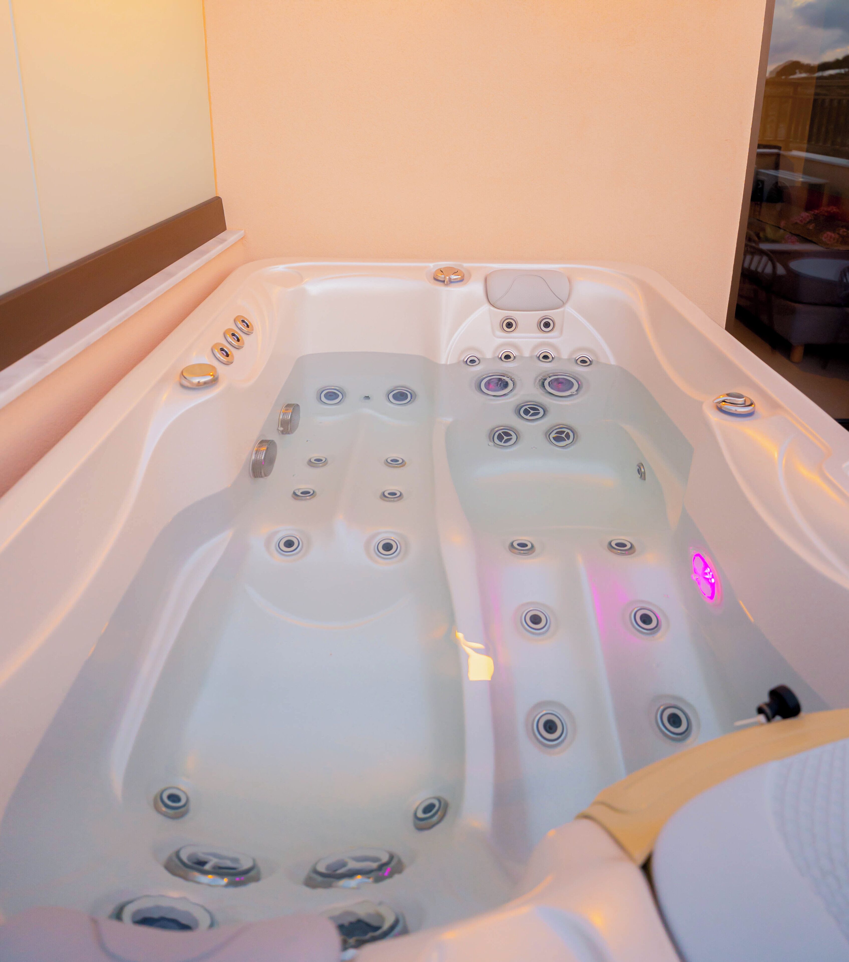 Un bain à remous doté de plusieurs jets et d’un panneau de commande.