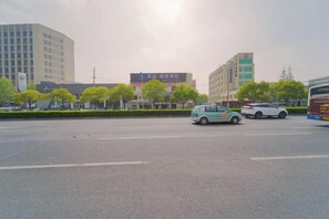A street with vehicles, buildings, and trees. - Fuzhijia Business Hostel (Shanghai)