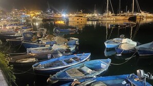 Un port de plaisance de nuit, avec différents bateaux amarrés.