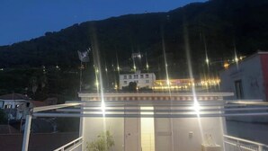 Un bâtiment doté d’un toit plat et de nombreuses fenêtres, entouré d’un paysage montagneux.