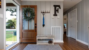 A wooden door with a wreath, a bench with shoes, a patterned rug, and a letter 'F' on the wall. - Cozy & Tasteful 3Br Cottage Walkable to Downtown (Franklin)