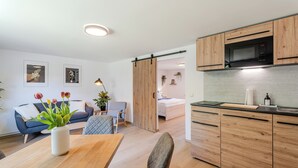 A modern apartment with a kitchen, dining area, and living room.