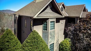 Une maison moderne avec un toit en pente, de grandes fenêtres et un garage.