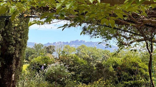 A stone wall with a view of a mountainous landscape. - Charming house (Travaillan)