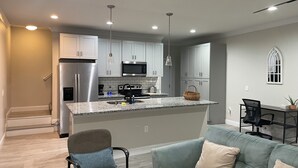 A modern kitchen with stainless steel appliances, a granite countertop, and pendant lighting. - 3-bedroom #1738 townhome in Cleveland—central air, ceiling fans, WiFi, cable. (Cleveland)