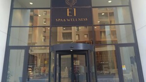 Une façade d’immeuble avec une enseigne indiquant « E1 SPA & WELLNESS ».