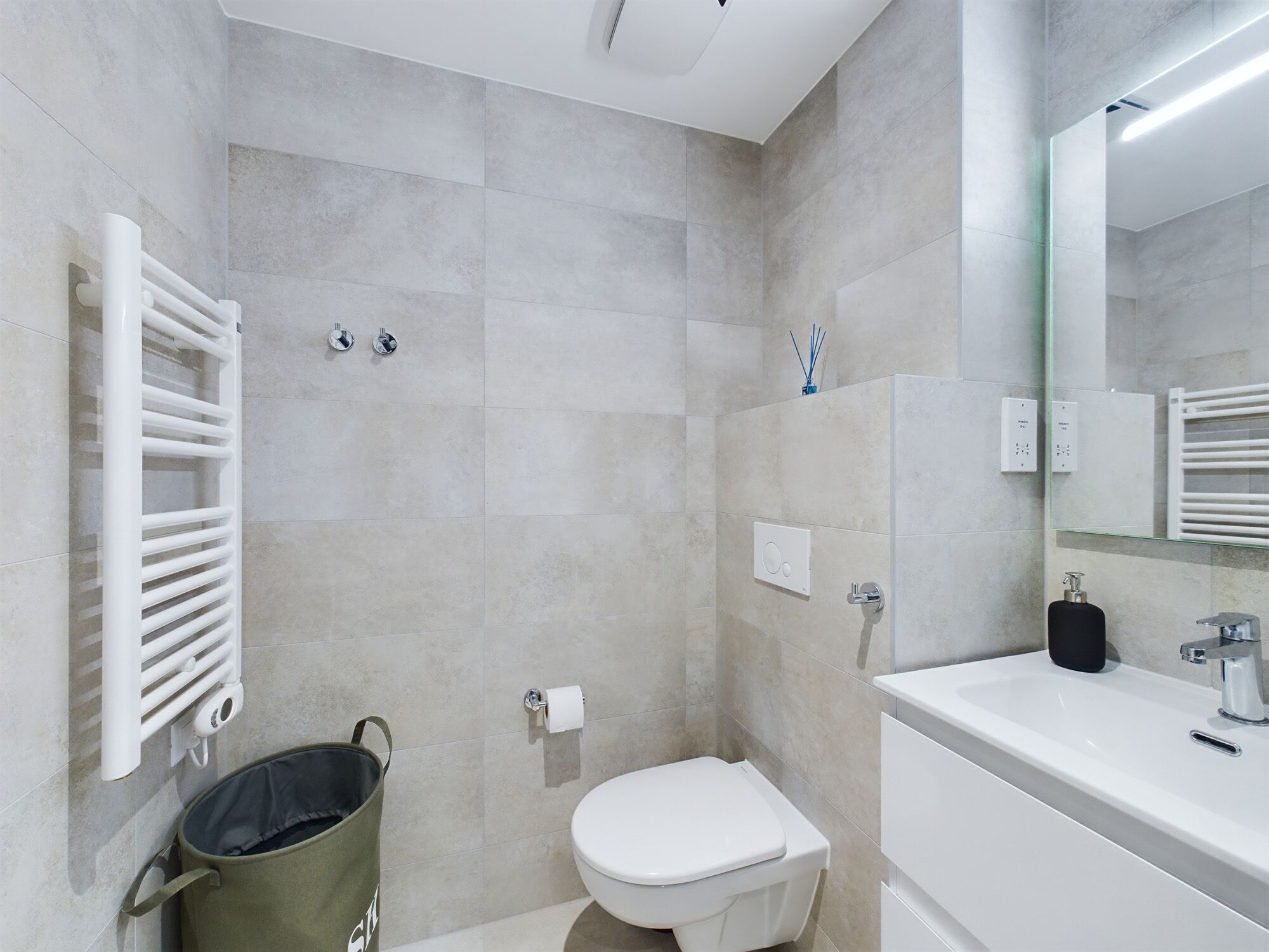 A modern bathroom with a shower, toilet, and sink.