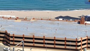 A parking area with multiple levels of parking garages and a beach in the background. - E1 18th Floor Studios - Scenic Sea & Beach Views (Gibraltar)