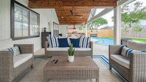 A covered patio area with wicker furniture, a coffee table, and a view of a backyard with a pool. - Casa Larissa , Grill & Chill Retreat- Heated Pool
3 bedroom Home in Katy TX (Katy)