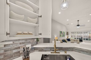 Un interior moderno con cocina, comedor y sala de estar con ventilador de techo.