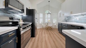 A modern kitchen with white cabinets, a black refrigerator, and a wooden floor. - Casa Larissa , Grill & Chill Retreat- Heated Pool
3 bedroom Home in Katy TX (Katy)