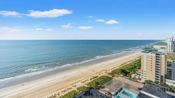 A beachfront hotel with a view of the ocean, a sandy beach, and a parking area. - Ocean View Palace Resort 1813- 2BR- Pool, Hot Tub (Myrtle Beach)