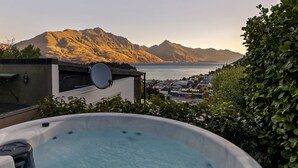 A hot tub with a view of mountains and a coastal town. - Central Sunset Charm is a stylish stay with stunning lake, mountain and city views in city centre. (Queenstown)