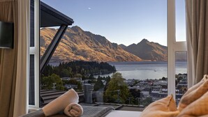 A room with a view of mountains and a body of water. - Central Sunset Charm is a stylish stay with stunning lake, mountain and city views in city centre. (Queenstown)