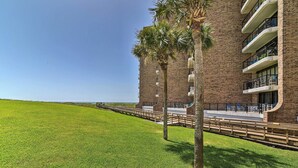 Un hotel con fachada de ladrillo, mobiliario exterior y vista al océano.