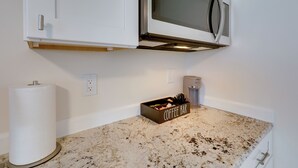 A kitchen with white cabinets, a microwave, a paper towel holder, and a coffee bar. - 3 Mi to Onset Beach & Village! Pet-Friendly Apt (Wareham)