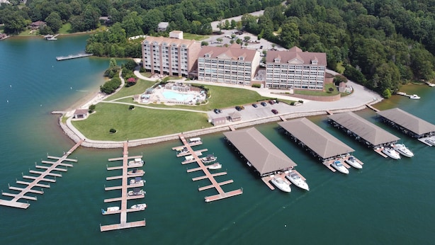 Eine Luftaufnahme eines Hotels mit mehreren Gebäuden, einer Marina mit angestaubten Booten und einer großen Grünfläche.