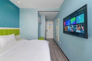 A hotel room with a bed, a TV mounted on the wall displaying a video, and a hallway leading to another room. - Lilai Hotel (Wendu Shuicheng store, Beijing) (Beijing)