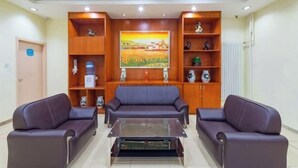 A lobby with two sofas, a coffee table, and a painting on the wall. - Lilai Hotel (Wendu Shuicheng store, Beijing) (Beijing)