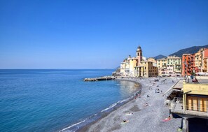 A coastal town with a pebble beach, colorful buildings, and a prominent tower. - 4 bedroom beautiful apartment in Camogli (Camogli)