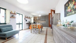 A modern kitchen with a dining area, a sofa, and a decorative vase. - Lovely home in Avella (Avella)